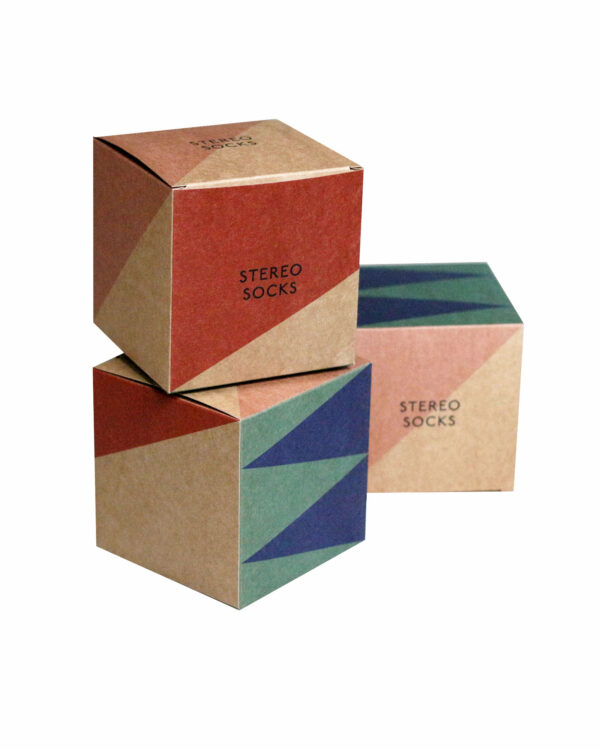 Drei Kartonwürfel mit farbigem geometrischem Muster und Stereo Socks Logo